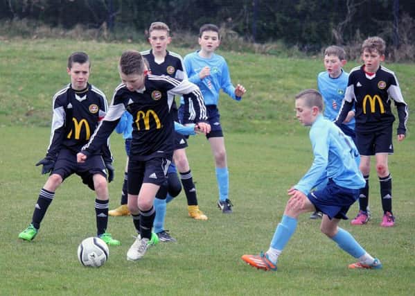 Carniny Youth take control in a crowded goalmouth during Saturday's match at Ballykeel. INBT 12-926H