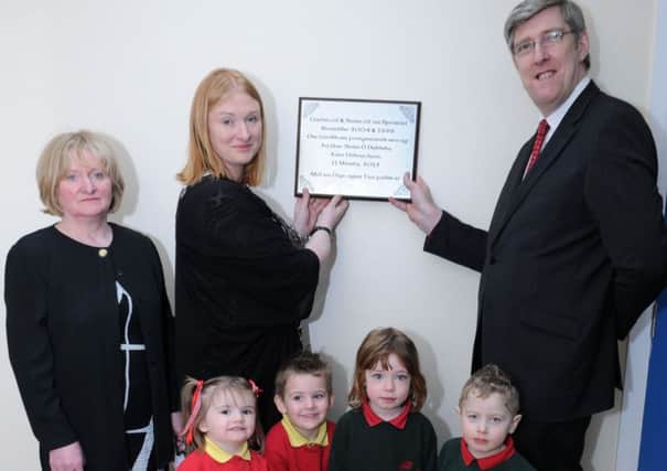 Education Minister John O'Dowd unveils a plaque to officially open the new facilities for Gaelscoil Na Speirini at Straw last Wenesday morning with the help of Principal Shauna Kelly, Tadringin Rafferty (Naiscoil Leader) and pupils.INMM1115-322