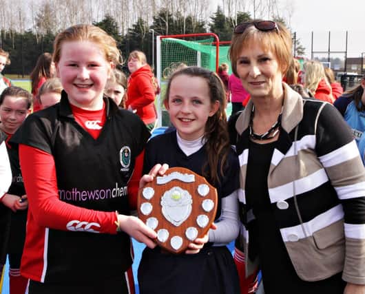 The finalists captains, Kenya McCartney of DH Christie and Amy Symington of Portstewart PS, share the trophy presented by Headmistress Mrs Bell at the Coleraine High School Primary Schools' Hockey Tournament at Rugby Avenue on Thursday. INCR12-334PL