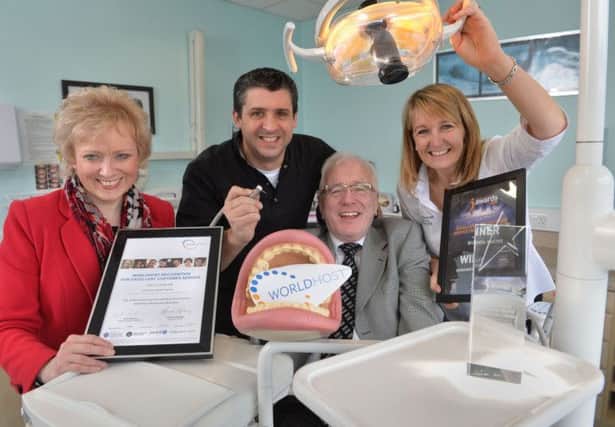 Philip  and Debbie McLorinan from Dunmurry Dental Practice receive their WorldHost Accreditation Certificate from
Lynda Willis, WorldHost and Alderman Allan Ewart, Chairman of the Council's Economic Development Committee.