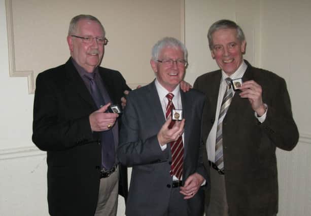 Robert McGonigle, centre, with brothers Winston and Raymond Robinson, members of Hamilton Flute Band, who were presented with their 50 Year Medals for services to banding in Northern Ireland.