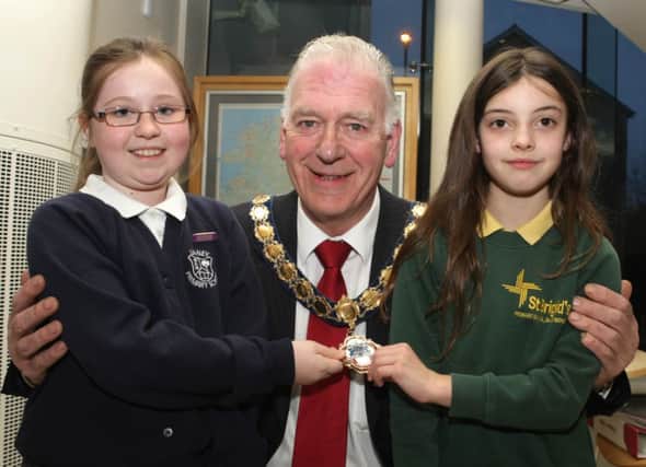 HIGHLIGHT. Mayor Alderman Bill Kennedy, pictured with Rhiannon McAfee (Leaney PS) and Ellie McConville (St Brigid's PS), who read some highlights of the past 42yrs.INBM13-15 005SC.