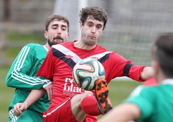 Dundela's David Gibson with Ballyclare's Chris Trussell. Photo: Presseye