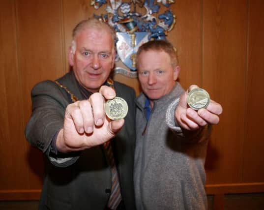 The Mayor of Ballymoney, Alderman Bill Kennedy, and community representative, Sammy McClements with the specially produced coin to mark the end of 42 years of Ballymoney Borough Council. One side of the coin depicts the various symobols on the Borough's Coat of Arms while the other celebrates the 100th anniversary of the First World War.