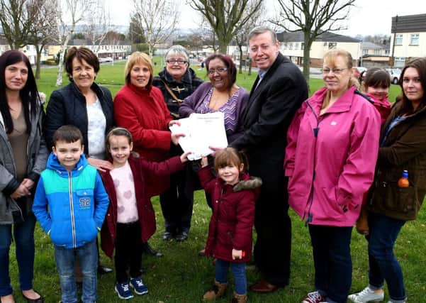Residents in Tonagh present a petition asking for a new play park to Councillor Paul Porter.
