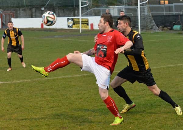 Larne's Ciaran Murray holds the ball up against Carrick's Conor McCloskey. INLT 13-010-PSB Photo: Phillip Byrne