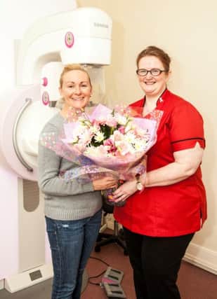 Dunmurry woman Angela Maxwell receives a bouquet of flowers from Action Cancers Consultant Radiographer Joanna Currie.