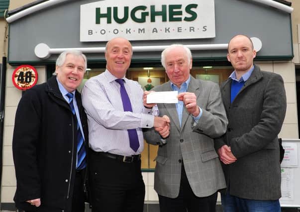 Gregory Hughes of Hughes Bookmakers Dungannon pictured as he hands over a cheque for £850 to Pat O'Kane representing Marie Curie Cancer Care. Included in the picture are Kevin Hughes (Head of Sport at the Mid-Ulster Mail & Tyrone Times) and Seamus Donnelly (Sports Reporter). The money is proceeds from the Mid-Ulster Mail & Tyrone Times Cheltenham charity bets.INTT1415-332