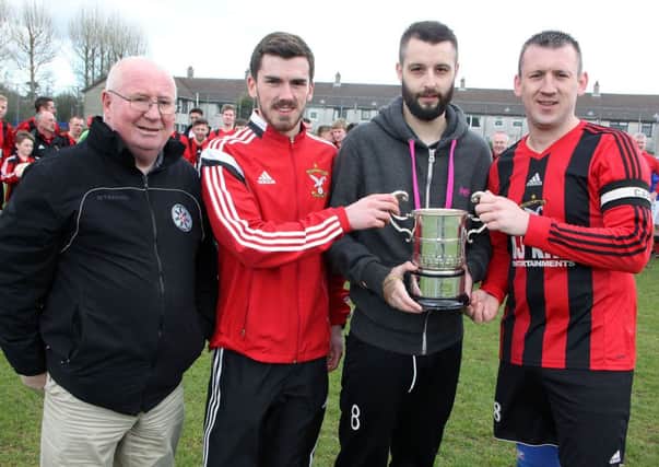 Jason Connolly, of sponsors County Antrim Post, presents the O'Kane Cup to Harryville Homers players David McWhirter and Gary Bonnes. Looking on is BSML secretary Brian Montgomery.