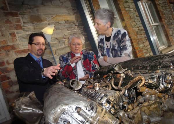 Johnny McNee and Barbara Kucharczy and Betty Wolfe, daughters of Roland 'Bud' Wolfe,with the recovered Spitfire engine at the Workhouse Museum three years ago. (0212PG55)