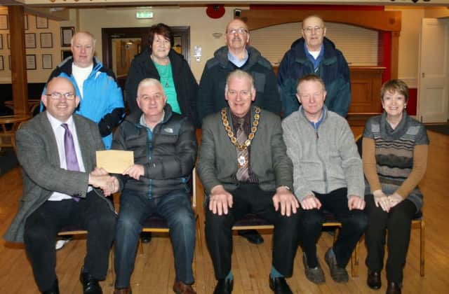 Councillor John Finlay (front left) presents the vice-chair of the Ballym0ney branch of the Royal British Legion, Hugh Elliott, with a cheque, the proceeds of a charity dinner in the RBL INBM17-15
