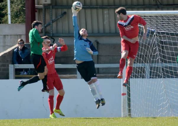 Ballyclare Comrades keeper Paddy Flood takes the ball out of the air to snuff out a dangerous cross in the 1-0 victory over the PSNI. INNT 16-050-GR