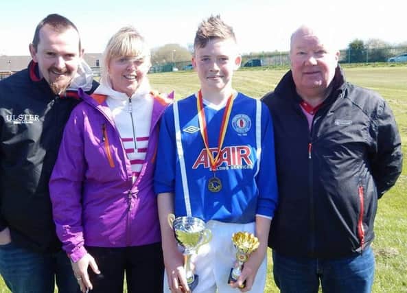 Man of the Match Russell Hilliland celebrates with family after Banbridge Rangers' cup final victory.
