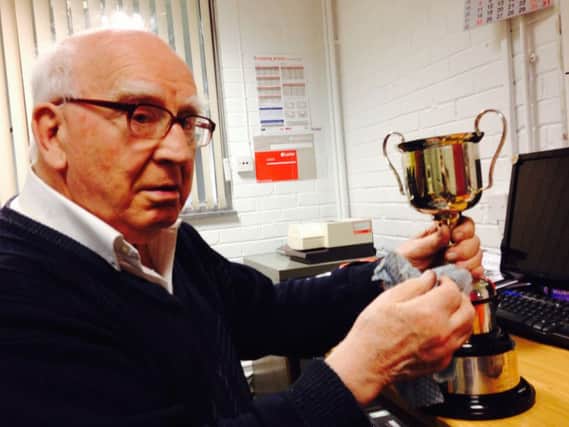 Alpha Chairman Bob Colhoun makes sure the trophies are sparkling for Saturday afternoon.