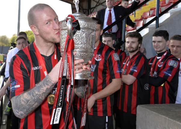 Crusaders striker Stephen O'Flynn kisses the Gibson Cup, on Saturday. Picture by Stephen Hamilton/Presseye
