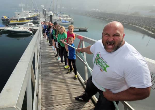 Strongman Dave Warner helps launch the Dalriada Festival sports programme at Glenarm Marina. Picture by Paul Faith.  INLT 17-680-CON