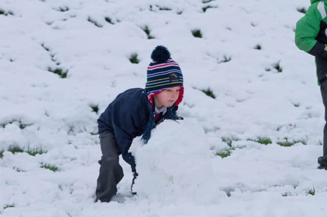 Killian Kenny helps make a snowman at Raheenagh National School