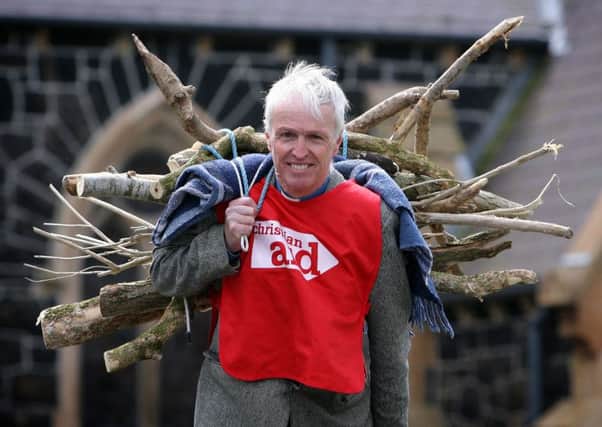 Canon Stuart Lloyd is pictured promoting Christian Aid week by recreating the struggle of Ethiopia woman Loko who would carry large bundle of sticks three times a week, at eight hours a time. INBT19-209AC