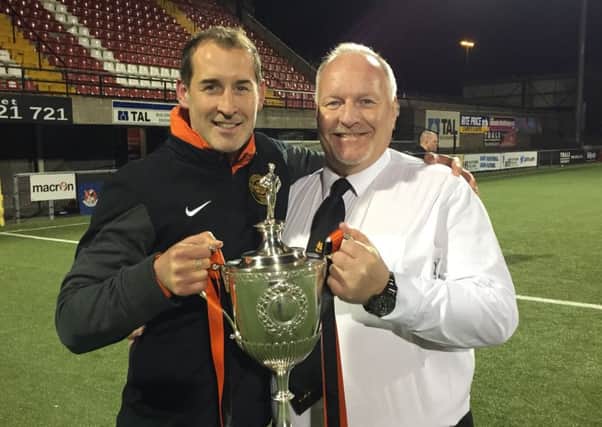 Carrick first-team coach Gary Haveron and club chairman David Hilditch with the Intermediate Cup.
