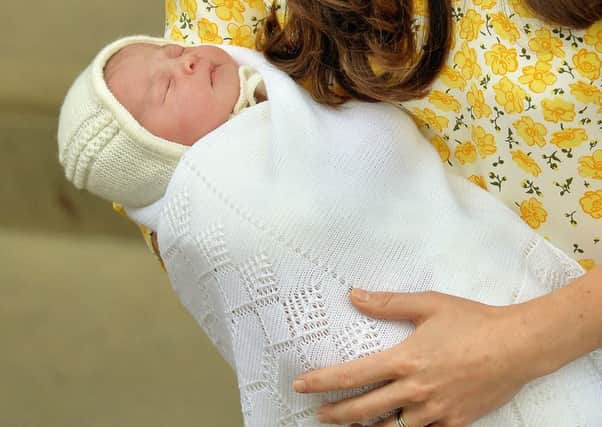 Princess of Cambridge in the arms of her mother outside the Lindo Wing of St Mary's Hospital in London yesterday