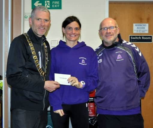 Gray Keenan (President of Athletics NI) presents Spriingwell's Gemma Turley with her prize for winning the Purple Ladies 5K along with Kenny Bacon (Race Director).