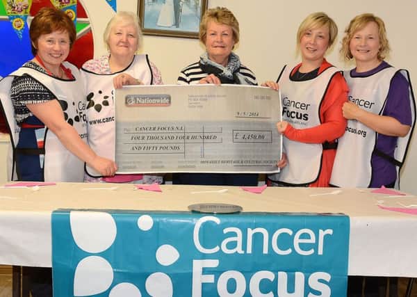 Betty Millar (centre) of Cancer Focus NI, is pictured receiving a cheque for £4450 from Fiona McCord, Eileen Wylie, Hollie McGaw and Tracey Burton, of Moyasset Heritage and Cultural Society who  raised the money from a social evening in Galgorm Community Centre. The money will go to Queens University to support research in various cancers. INBT20-252AC