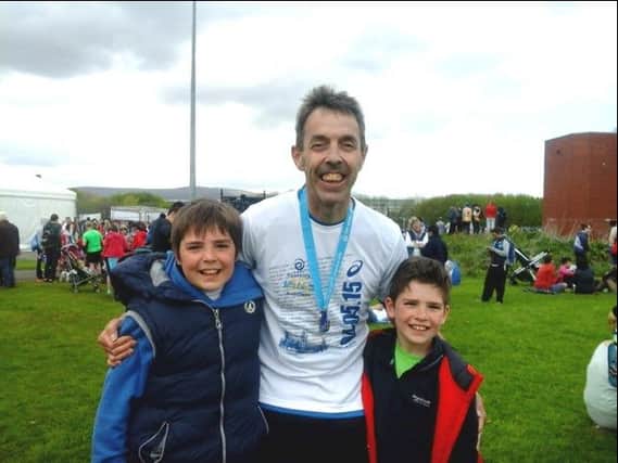 Lisburn man Julian Netherton, pictured with proud sons Jack and Sam, after completing the Belfast Marathon, raising £700 for the work of Abaana in Uganda.