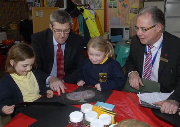P2 pupils Abbie McGuire and Emily Mackey show their drawings to Education Minister John O'Dowd MLA, when he paid a visit to Ebrington Primary School on Thursday. Included is Nigel Dougherty, Principal. INLS4411-163KM