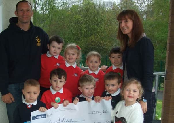 Tracey Cassells principal of Barbour Nursery School with children presenting a cheque to the Boom Foundation