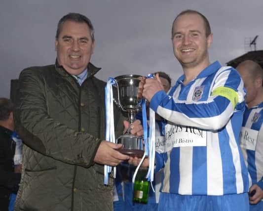 Mid Ulster Football League Chairman Sean O'Neill presents the Alan Wilson Cup to Moneyslane Captain Gareth Bingham ©Paul Byrne Photography 1520-234PB
