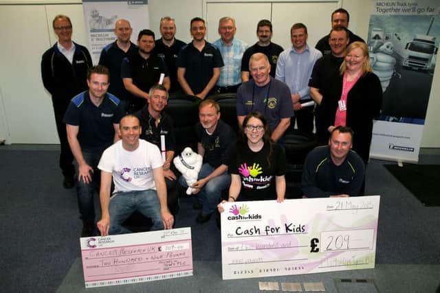 Staff from Michelin are pictured presents cheques each for £209 to Mark McMahon (Fundraising Manager) Cancer Research and Stephanie Laverty (Charity Manager) Cash for Kids, money raised by a Pound for Pound challenge where the staff lost weight totaling 418lbs and Michelin donated £418 to the charities. INBT22-210AC