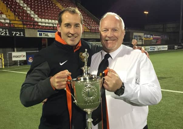 Carrick Rangers chairman David Hilditch and first-team coach Gary Haveron with the Intermediate Cup - one of three trophies the club won last season.