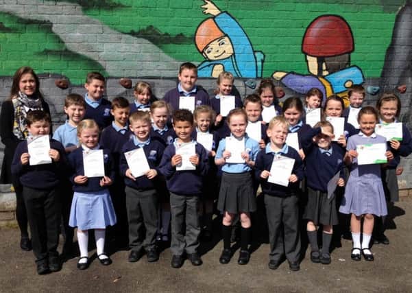 Sarah Duff, Action MS schools project officer,  and children from Glengormley Integrated Primary School. INNT 21-600-CON