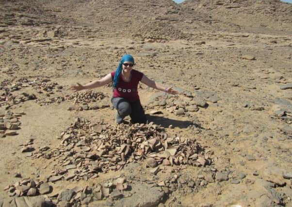 Dr Sarah Doherty pictured with pottery shards at Gebel el Silsila. INNT-21-700-con