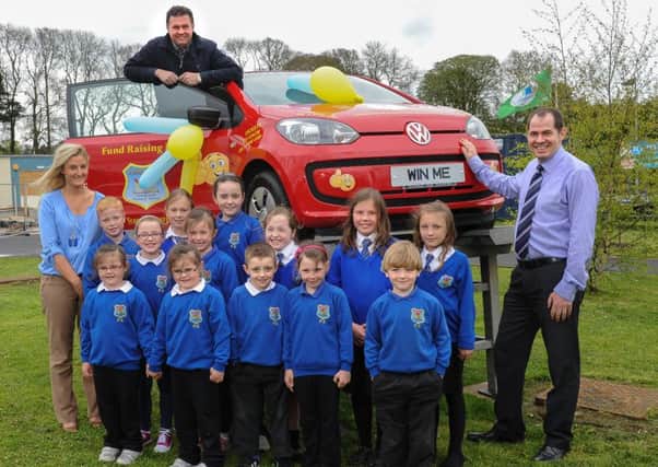 Phoenix Integrated Primary School, Cookstown staff Stephen Kelly and Cherith Martin are pictured with pupils as they are joined by Eamon Bradley, from EJB Car Sales at the launch of the prize draw with the top prize of a Volkswagen UP car, as part of the School's 10th anniversary celebrations. INMM18-506.