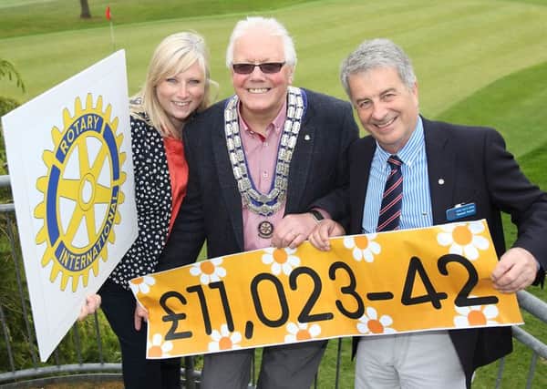 Ana Wilkinson from Cancer Fund For Children receiving a cheque for £11,023 from Sam Patterson, president of Lisburn Rotary Club, and Richard Darrah, Rotary member, at Dunmurry Golf Club. US1521-517cd  Picture: Cliff Donaldson