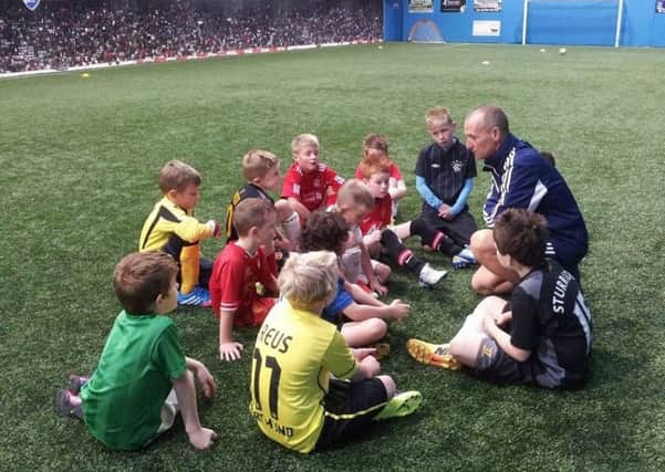 A new youth football tournament is to be created in memory of local coach Wesley Gregg, pictured here passing on his expertise to a group of youngsters.