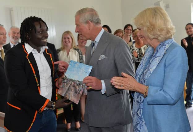 Corrymeela Volunteer Michael Maundu from Kenya presenting Prince Charles with one of his paintings.