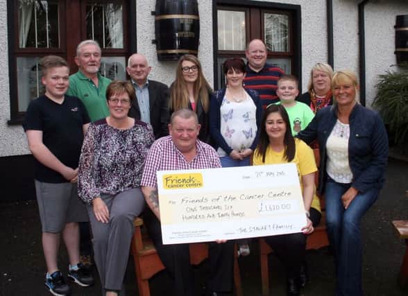 Claire Hogarth from Friends of the Cancer Centre accepts a cheque for £1620 from Robert Stewart at The Scenic Inn. Included are members of Robert's family, Shirley McKinley, from the Scenic and Tom Christie who helped with the fund-raising.