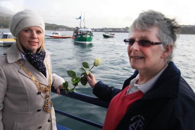 Mayor Michelle Knight McQuillan and Kate O Connor from Ballycastle Church action lay flowers at the Blessing of the Boats
