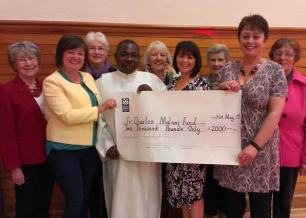 Daughters of the late Mary Thompson (Joan, Marian and Brenda) and parishioners from St Patrick's present Fr Charles with a cheque for £2,000 for his parish in Malawi. INCR25-15 UC