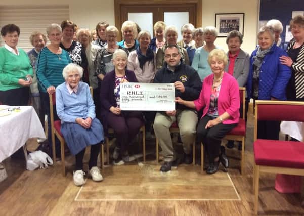 A cheque is handed over by Portrush WI members to Portrush RNLI.