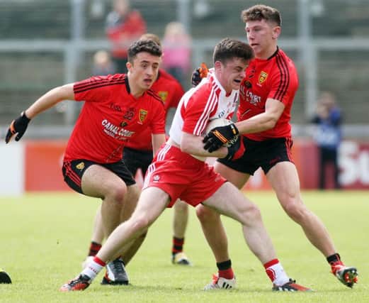 Derry's Eoghan Colcannon comes under pressure from Down's Darragh Connolly and Pierce Laverty in Celtic Park. (Photo: Lorcan Doherty / Presseye.com)