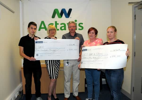 Peter Chestnutt, Janice Purvis and Helen Spoor from Activis, Millbrook, present two cheques in memory of their late colleague, Paul Hunter, who died in September 2014. Julie Whitley from Sense NI accepted a cheque for £600 and Chest Heart and Stroke NI received a £600 cheque. Also pictured on the left is Paul's Son, Matthew. INLT 23-204-AM