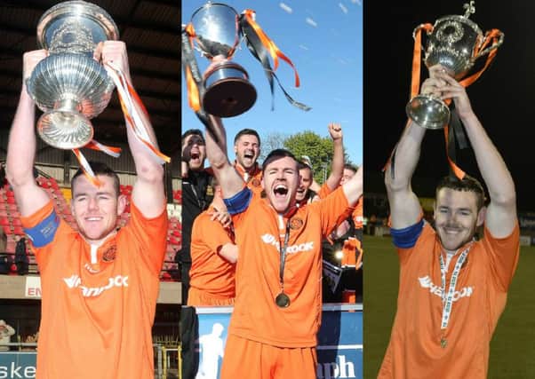 Anything Barca can do ... Carrick skipper Aaron Harmon lifting the Steel and Sons Cup, the Championship 1 title and the Intermediate Cup.