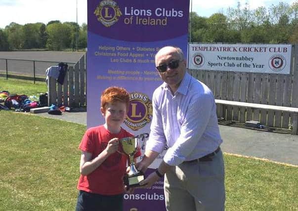 David Bingham from Antrim Lions Club presents the TCC Kwik Cricket Competition trophy to the captain of the winning team from Fairview Primary School. INLT 25-911-CON