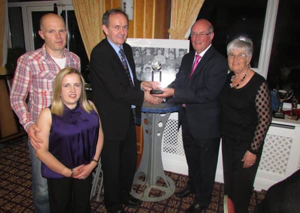 Ballymena & Provincial League chairman Ian Shiels presents a memento to secretary Billy McIlroy, marking his 50 years of service to the league. Included are Billy's wife Pat, daughter Lisa and son-in-law James Stewart.