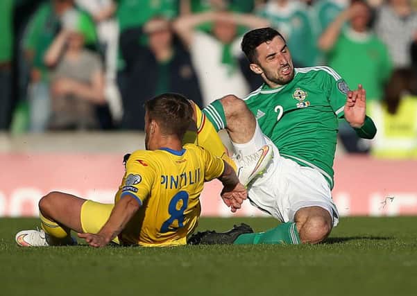 Northern Ireland's Conor McLaughlin puts in a tough tackle on Romania midfielder Mihai Pintilii during Saturday night's EURO 2016 qualifier at Windsor Park. Picture by Brian Little/Presseye