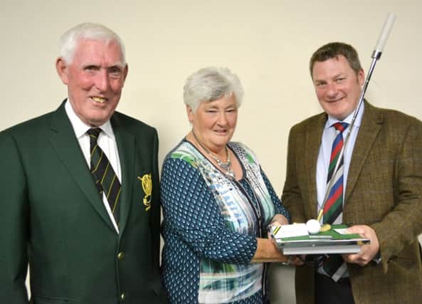 The Captain's Prize winner Girvan Gault receives his award from Mrs Amy Boyd and Captain John Boyd.