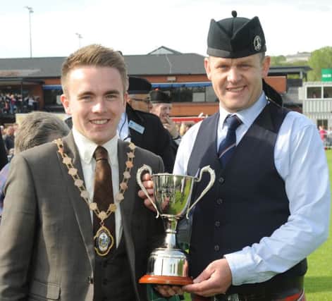 Pipe Major Nigel Davison (Bleary & District Pipe Band) pictured receiving the Grade 3 UK Champion trophy from the Chieftain of the Gathering Alderman Guy Spence (Deputy Lord Mayor of Belfast) at the United Kingdom Pipe Band & Drum Major Championships at Stormont Estate, Belfast on Saturday 13th June.